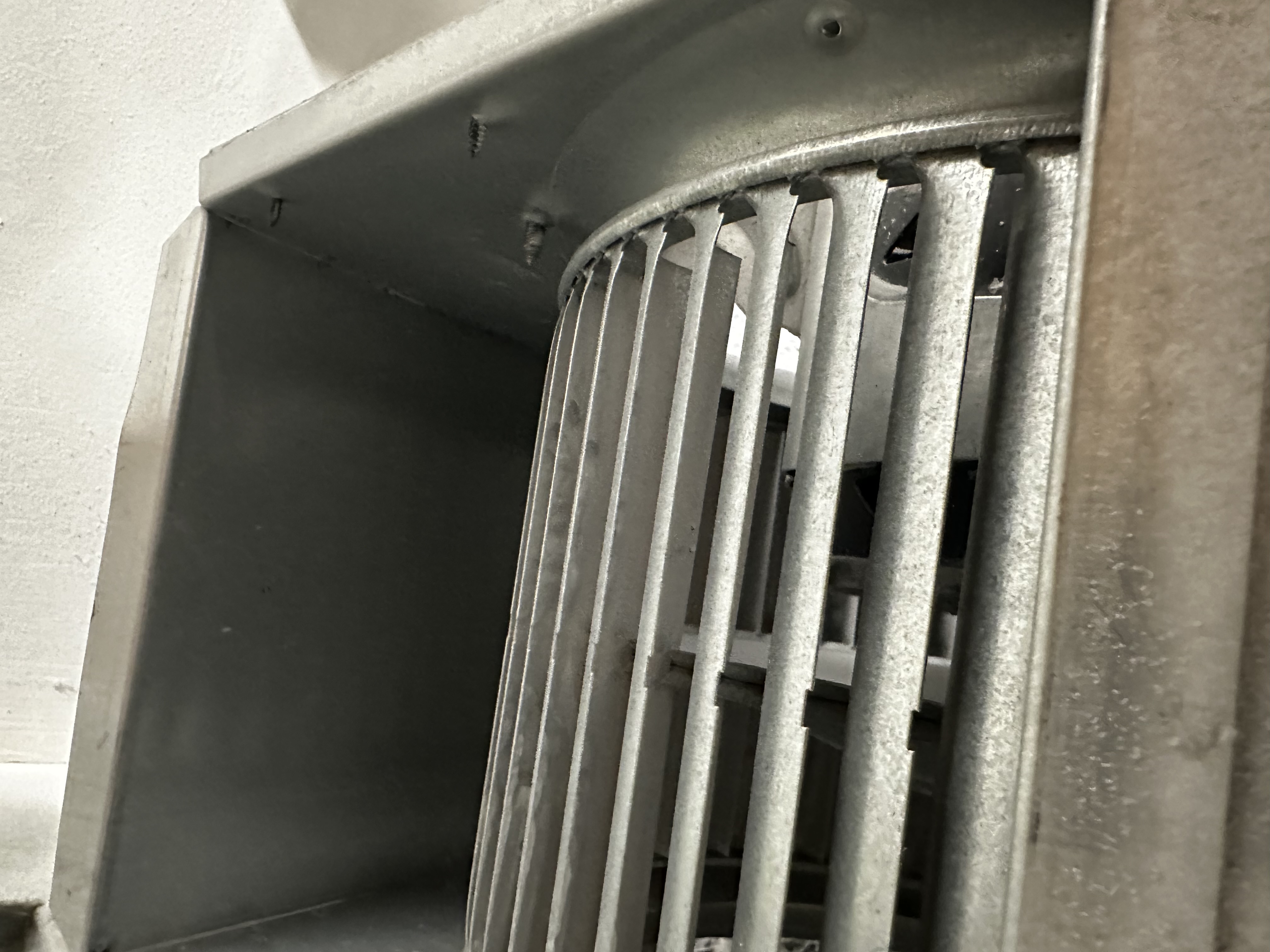 Squirrel-cage furnace blower wheel before and after cleaning, showing heavy dust buildup removed