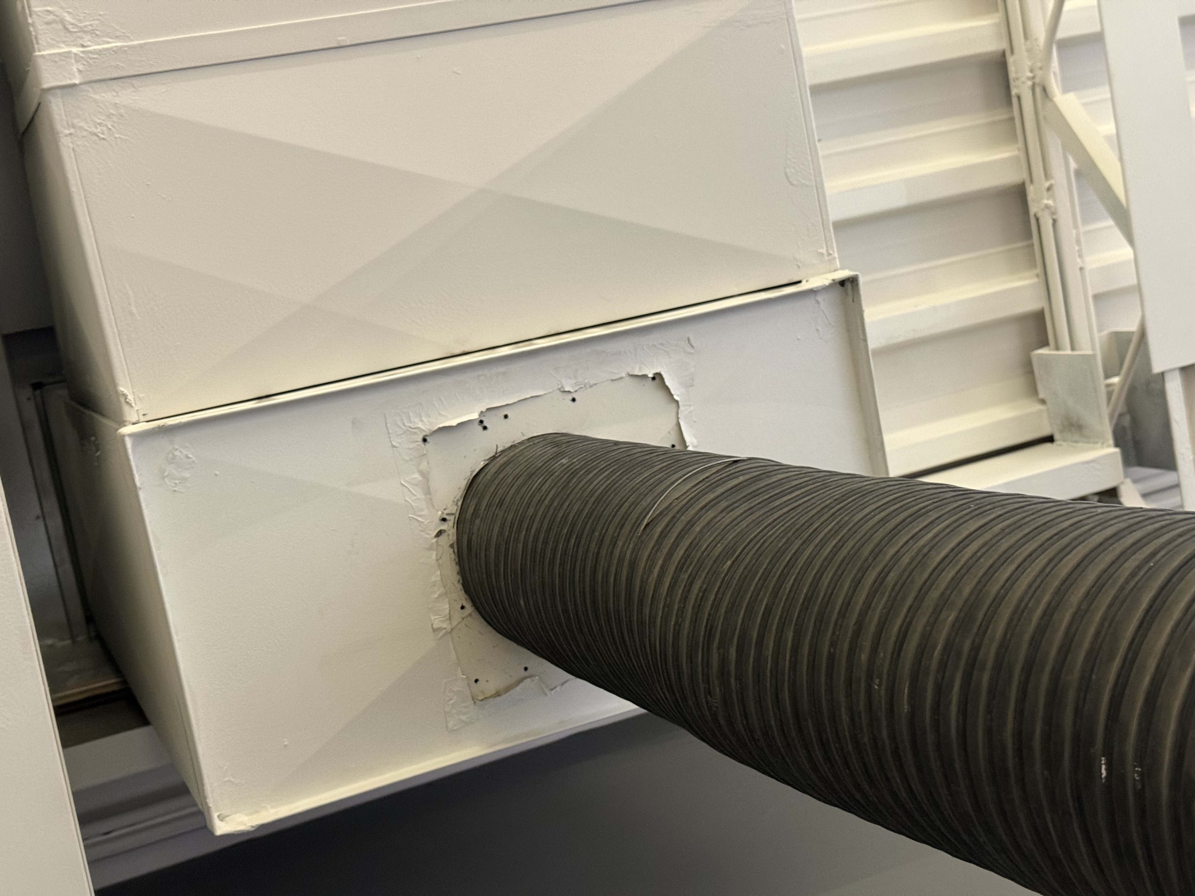 Home Pros Group KOP75 negative-air vacuum sealed to the ductwork above a residential furnace